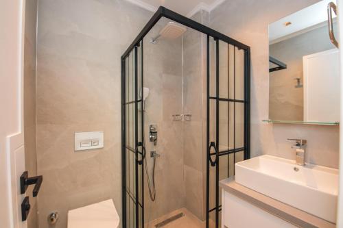 a shower with a glass door next to a sink at Asfiya Loft Apartments in Kalkan
