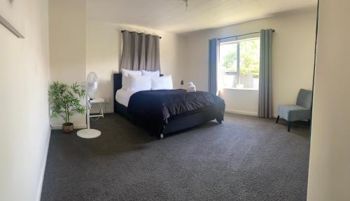 a bedroom with a bed and a window at The Park Cottage in Napier