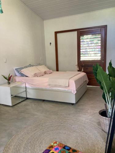 a bedroom with a large bed and a window at Casa Filtro Morere in Cairu