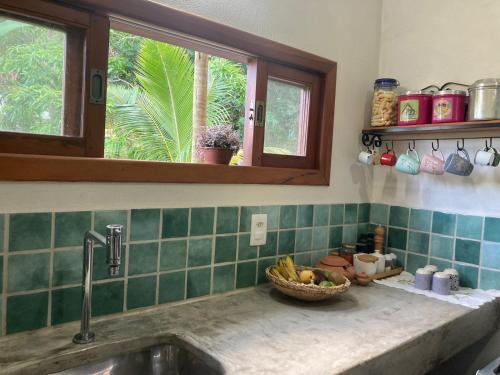 a kitchen counter with a sink and a basket of fruit at Casa Filtro Morere in Cairu