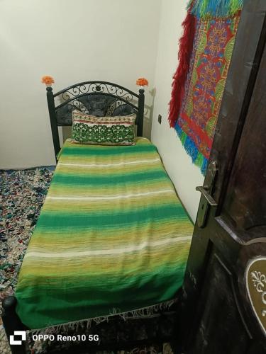 a bedroom with a bed with a colorful blanket at Gite souran in Imlil
