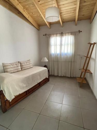 a bedroom with a bed and a wooden ceiling at Cabaña Lazarillo in Amaicha del Valle