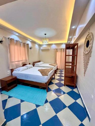 a bedroom with two beds and a checkered floor at Saray Hotel Dahab in Dahab