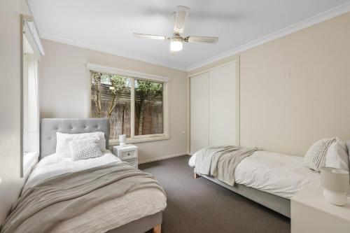 a bedroom with two beds and a window at Bay Breeze in Cowes