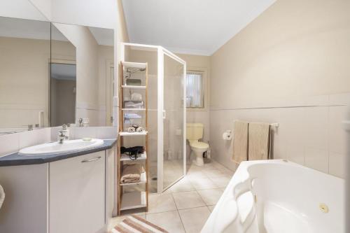 a white bathroom with a sink and a toilet at Bay Breeze in Cowes