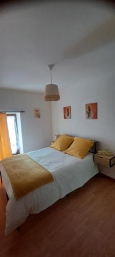 a bedroom with a large white bed with yellow pillows at L'auberge du Houx in La Houssière