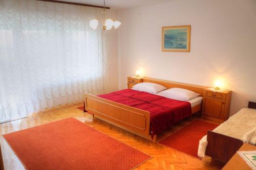 a bedroom with a bed with a red blanket at Apartment Crikvenica 19 in Crikvenica