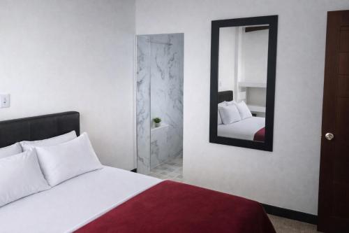 a bedroom with a bed and a mirror at Casa Almarita Hostel Social Bar in Medellín
