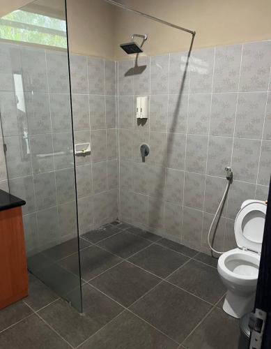 a bathroom with a shower and a toilet at Melaya Beach Resort Queen Bed in Penginuman
