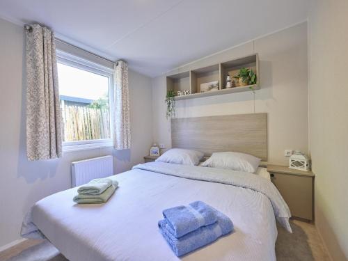 a bedroom with a large bed with two towels on it at Sunseeker in Goedereede