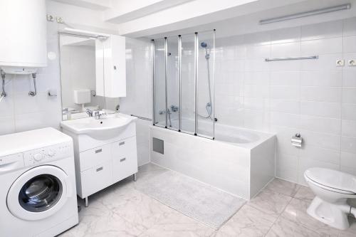 a white bathroom with a washing machine and a sink at Villa Andy -private yard, swimming pool, panoramic view in Imotski