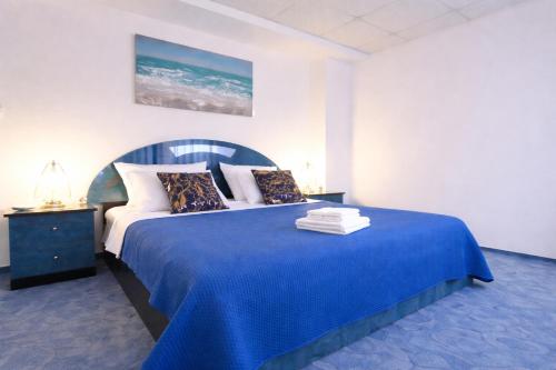 a bedroom with a blue bed with a blue blanket at Villa Andy -private yard, swimming pool, panoramic view in Imotski