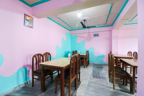 a dining room with pink and blue walls at Hotel O Dp Bar in Rāmpur