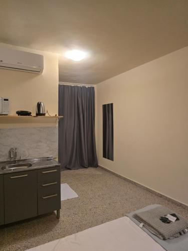 a room with a sink and a kitchen with a window at Ideal Center in Nova Serrana