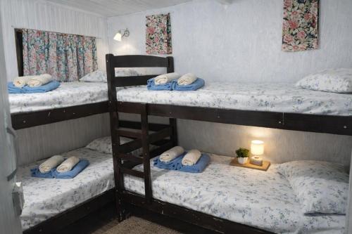 a room with three bunk beds and a lamp at Pousada e Hostel Cantinho dos Chalés in São Luiz do Paraitinga