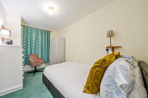 a bedroom with a bed and a chair in it at Charming Garden Flat in Kent