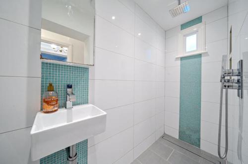 a white bathroom with a sink and a shower at Charming Garden Flat in Kent