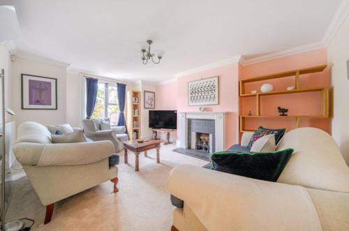 a living room with two couches and a fireplace at Charming Garden Flat in Kent