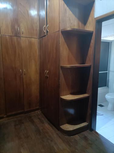 a bathroom with wooden cabinets and a toilet at Bodegon in Encarnación