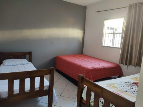 a bedroom with two beds and a window at Casa Garcia in Ilha Comprida