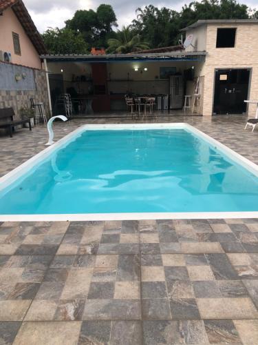 a large blue swimming pool in a yard at Casa da mãe joanna in Guapimirim
