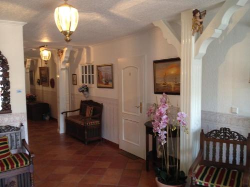 a hallway of a home with chairs and flowers at Inselhotel Arfsten in Wyk auf Föhr