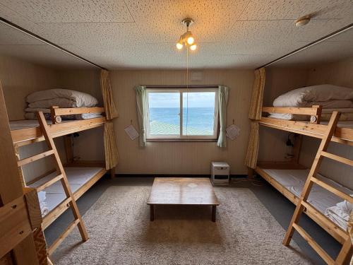 a room with four bunk beds and a window at Rishiri Greenhill Inn in Oshidomari