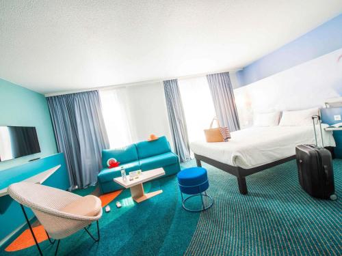a hotel room with a bed and a chair at ibis Styles Toulon Centre Port in Toulon