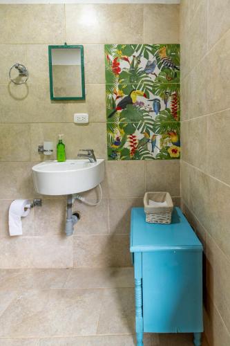 a bathroom with a sink and a blue table at La cabaña del Búho in Cali
