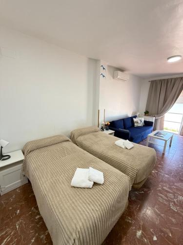 two beds in a hotel room with towels on them at A la Orilla del Mar in Matalascañas