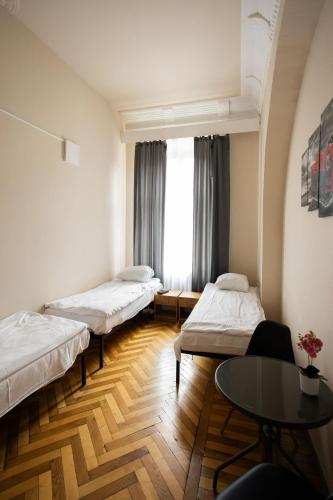 a hospital room with three beds and a table at FiveHostel in Krakow