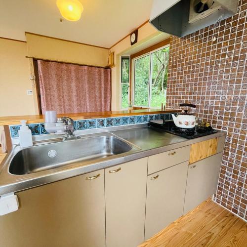 a kitchen with a stainless steel sink and a window at salvia blue in Miyazaki