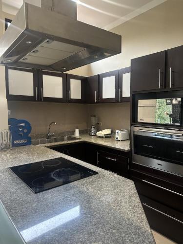 a kitchen with a sink and a stove top oven at Posada El Remanso de Pueblo Nuevo in San Cristóbal