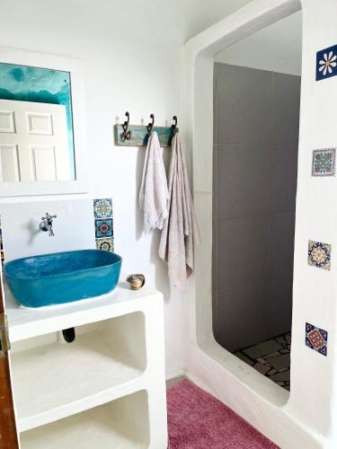 a bathroom with a blue sink and a shower at Jambalau House in Lopes