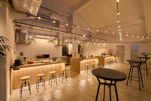 a kitchen with stools and a table in a room at GRAND HOSTEL LDK Tokyo Nishikasai -GRAND OPENING In May 2025- in Tokyo