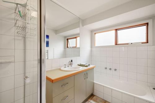 a bathroom with a sink and a tub and a shower at Beach House Silverleaves in Cowes