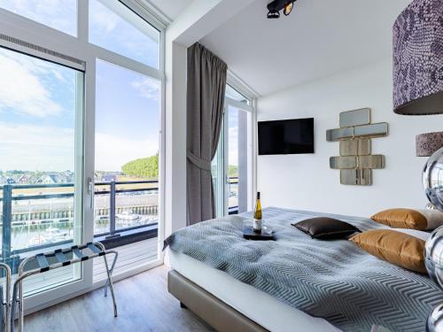 a bedroom with a bed and a large window at Penthouse with beach view in Sint Annaland