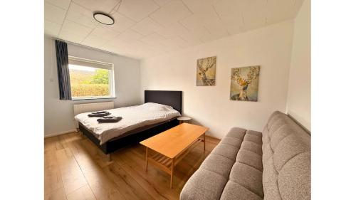 a small bedroom with a bed and a couch at 4 Bedrooms Cozy & Spacious Villa - Lalandia & Puttagrden & Femern in Rødby