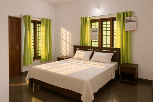 a bedroom with a large bed with green curtains at Casa Horizon in Sultan Bathery