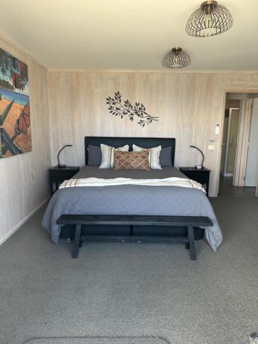 a bedroom with a large bed with two night stands at Te Mata Bay Seaviews in Tapu