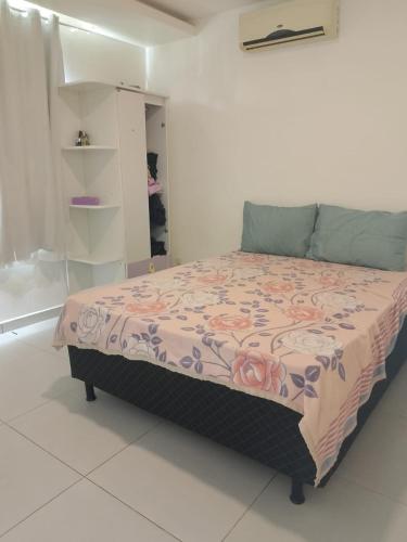 a bedroom with a bed with a pink and purple blanket at Recanto da gell in Búzios