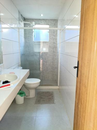 a bathroom with a shower and a toilet and a sink at Recanto da gell in Búzios
