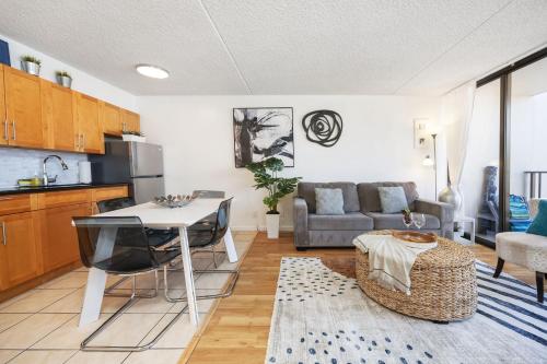 a kitchen and living room with a table and a couch at 17FL Fully Renovated, 5 mins to Beach with Parking in Honolulu
