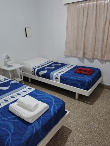two beds sitting in a room with a window at DepartamentoJAP in Venado Tuerto
