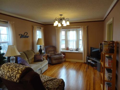 a living room with a couch and chairs and windows at 2 Blks St Marys 2 Main Fl Beds Bath CoveredByFaith in Rochester