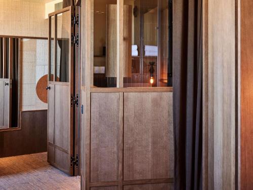 a room with wooden sliding doors and a room with at Mercure St Malo Front de Mer in Saint Malo