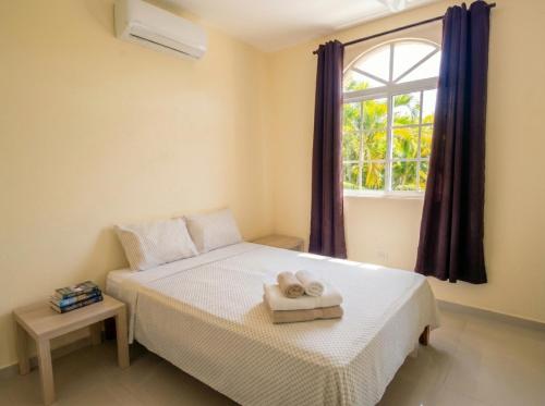 ein Schlafzimmer mit einem Bett und einem Fenster in der Unterkunft Costambar in San Felipe de Puerto Plata