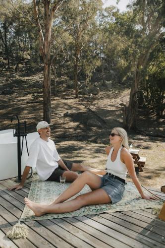 a man and a woman sitting on a blanket at Tiny Maggie in Rylstone