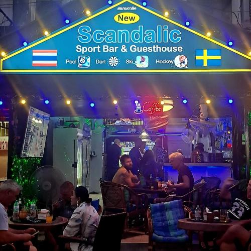 a group of people sitting at tables in a bar at Scandalic Bar and Guest house in Pattaya