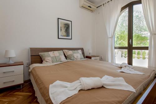 a bedroom with a large bed with a window at Villa Paradiso in Donji Morinj